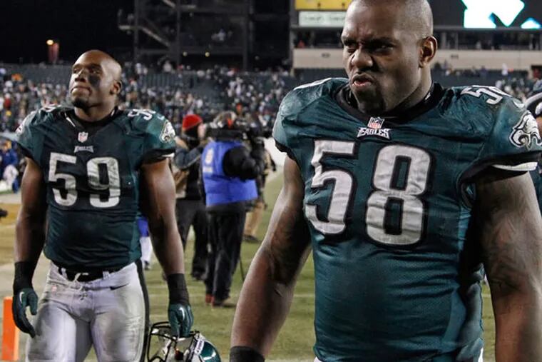 DeMeco Ryans (left) and Trent Cole walk off the field after losing to the Saints. (Ron Cortes/Staff Photographer)