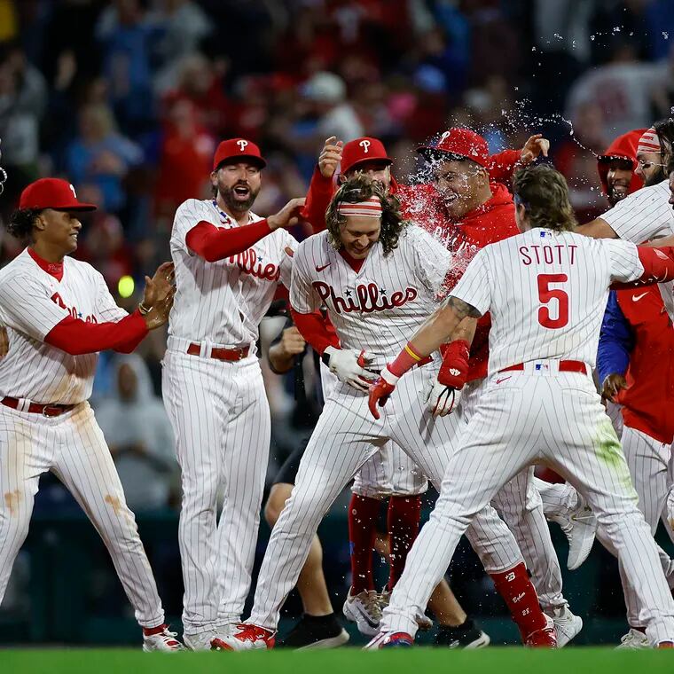 Alec Bohm (center) celebrates with his teammates after his walk-off single in the 10th inning Friday against the Mets.