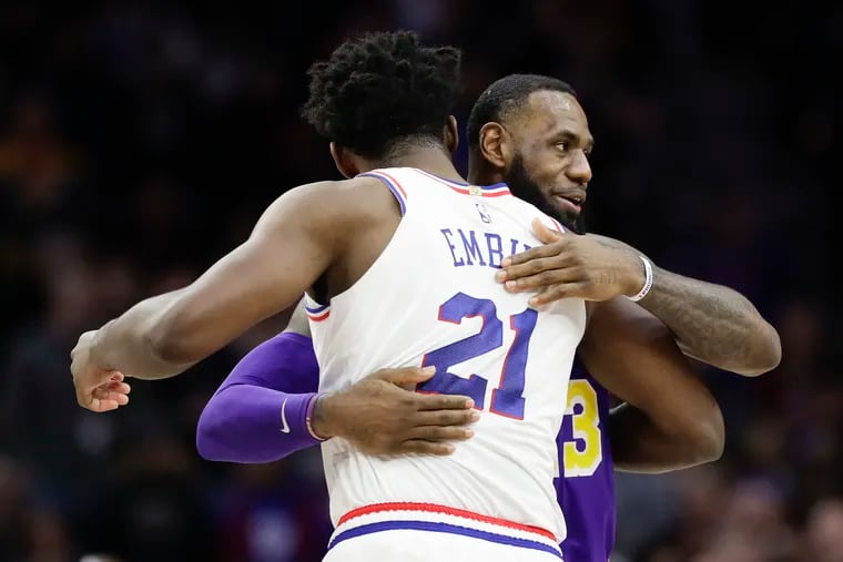 Sixers center Joel Embiid greets the Lakers' LeBron James.