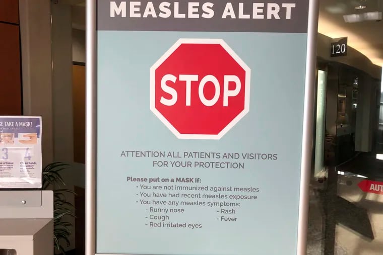 In this Jan. 30, 2019 photo, signs posted at The Vancouver Clinic in Vancouver, Wash., warn patients and visitors of a measles outbreak.