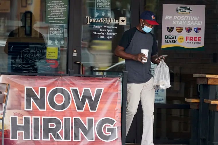 A customer walks past a now-hiring sign at an eatery in Richardson, Texas.
