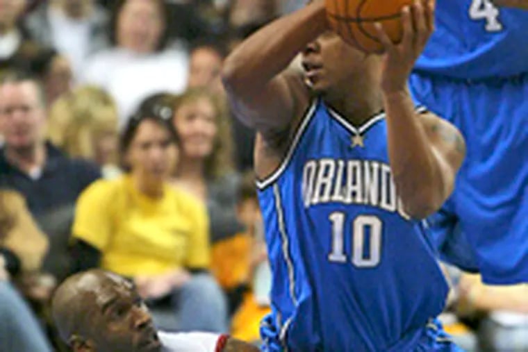 Orlando&#0039;s Keith Bogans looks to pass after a scramble with the Sixers&#0039; Joe Smith (left). The Magic won, 104-87.