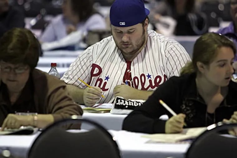 Joe Cosella, from Northeast Philadelphia, sports his Phillies garb while warming up for the Sudoku competition at the Pennsylvania Convention Center in Philadelphia today. (Laurence Kesterson / Inquirer)