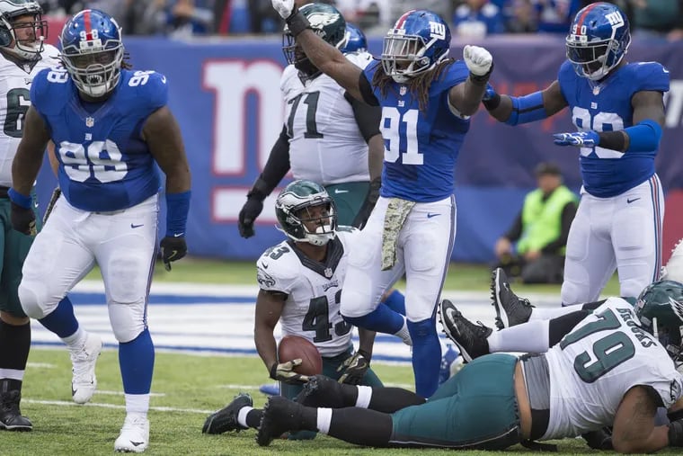 Eagles’ Darren Sproles looks dejectedly at jubilant Giants’ defenders after failing to get first down on fourth-and-1 in second quarter.