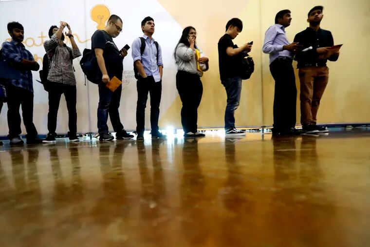 In this Sept. 17, 2019, photo job seekers line up to speak to recruiters during an Amazon job fair in Dallas. On Friday, Oct. 4, the U.S. government issues the September jobs report.