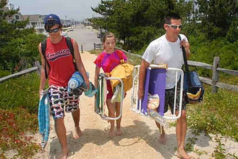 Jacob (left) and Michaela Hill and their father, Stewart, walk from 75th Street to the ocean in Avalon. Area heat records could fall today and tomorrow. (April Saul / Staff)