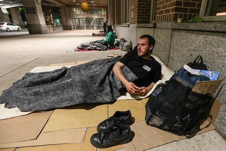 Matt, 28, of Montgomery County, gets ready for bed under the Pennsylvania Convention Center.