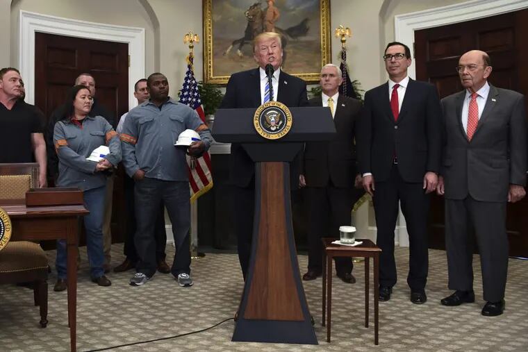 President Trump (center) speaks in the Roosevelt Room of the White House before signing two proclamations, one on steel imports and the other on aluminum imports. Standing with Trump are workers (left) Vice President Mike Pence, Treasury Secretary Steven Mnuchin, and Commerce Secretary Wilbur Ross.