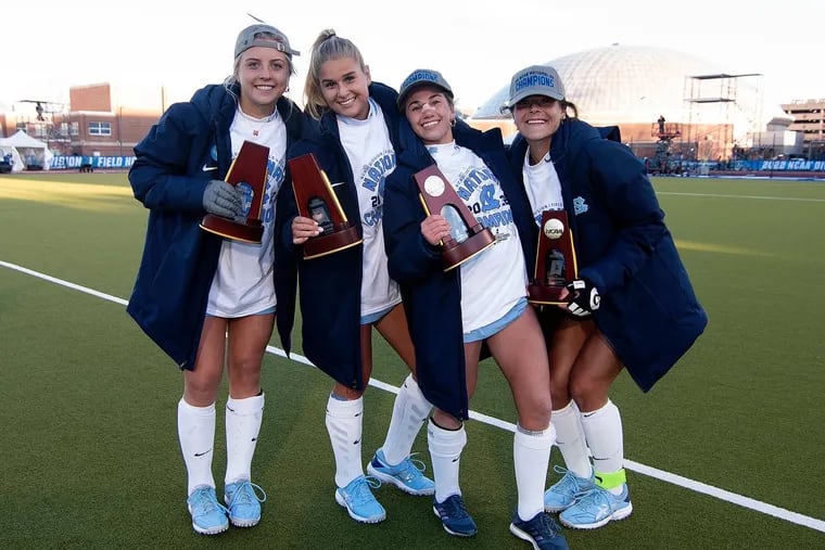 From left: UNC's Ryleigh Heck, Jasmina Smolenaars, Ashley Sessa, and Meredith Sholder pose with their NCAA championship trophies after defeating Northwestern, 2-1, on Nov. 20 for the Division I field hockey title.
