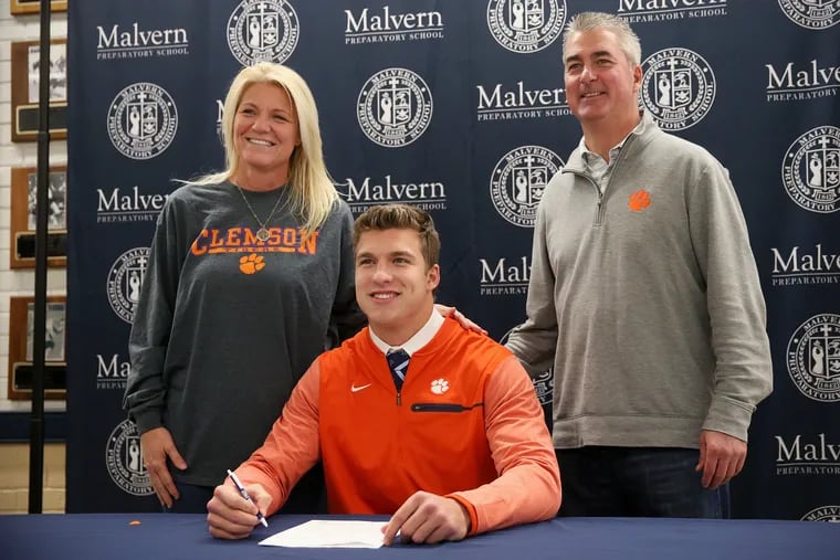 Malvern Prep's Keith Maguire, who will attend Clemson, poses with his parents, Jenine, left, and Keith Sr., right, during the school's signing day ceremony.