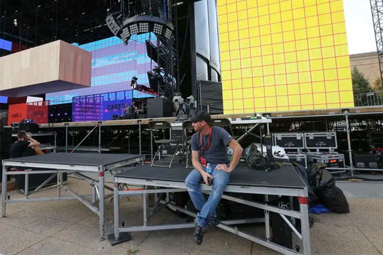 Camera operator Brian Latie takes a break as workers ready the stage and the Parkway for Made in America. (DAVID SWANSON / Staff Photographer)