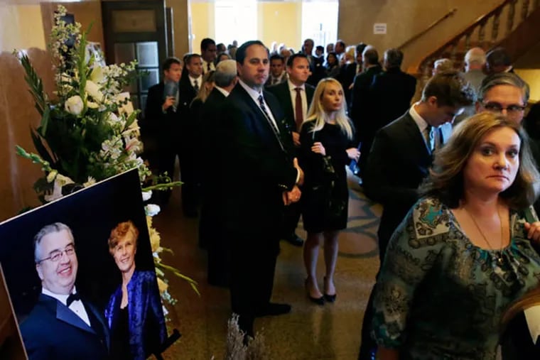 People file past a portrait of John and Joyce Sheridan, into a memorial service for the couple at the War Memorial Tuesday, Oct. 7, 2014, in Trenton, N.J. Gov. Chris Christie and former Govs. Tom Kean and Christie Whitman, all Republicans, are expectec to be among the mourners Tuesday at a service for John and Joyce Sheridan. John Sheridan was president and CEO of Camden-based Cooper University Health Care and previously held high-ranking jobs in state government. His wife was a retired teacher. Their Montgomery Township house burned Sept. 28 in a fire that has been ruled an arson.  (AP Photo/Mel Evans)