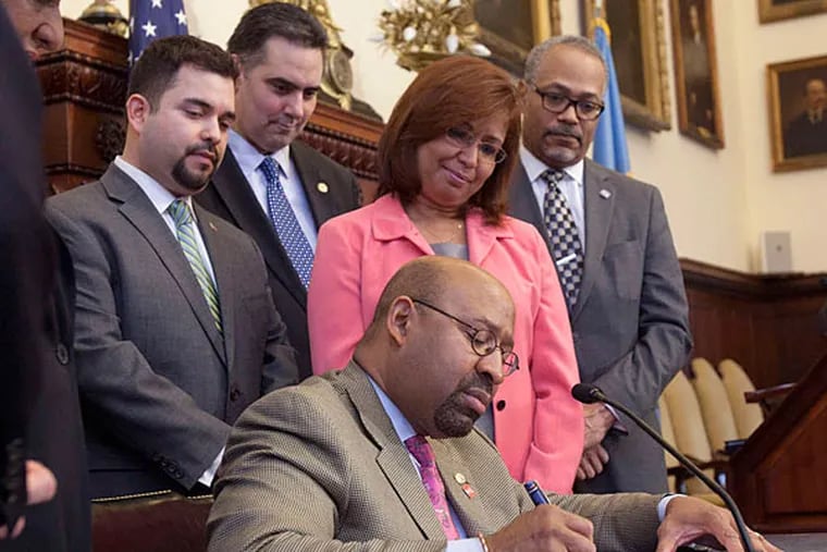 Mayor Nutter signs an executive order ending &quot;ICE holds&quot; in Philadelphia. Behind him are (from left) Fernando Trevino of the mayor's Office of Immigration; Managing Director Richard Negrin; Councilwoman Maria Qui&#0241;ones S&#0225;nchez; and the mayor's chief of staff, Everett Gillison. (Ed Hille/Staff)