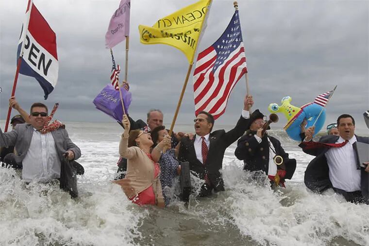 At Ocean City's Moorlyn Terrace beach , a group in business suits with attache cases marches in the surf to the strains of &quot;Pomp and Circumstance.&quot; There were celebrations of the new tourism season up and down the Jersey Shore. AKIRA SUWA / Staff Photographer