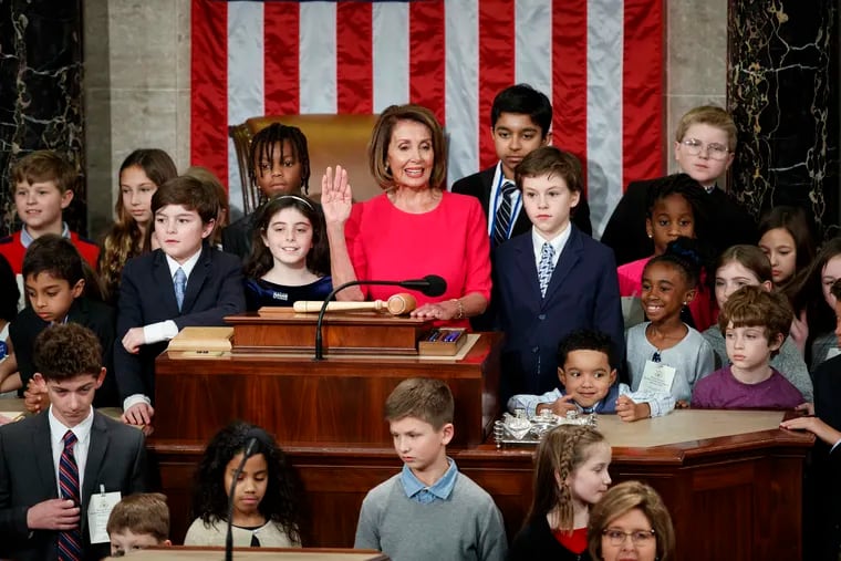 Nancy Pelosi of California, surrounded by her grandchildren and other children raises her right hand as Rep. Don Young, R-Alaska, the longest-serving member of the House, administers the oath to Pelosi to become the Speaker of the House Thursday.