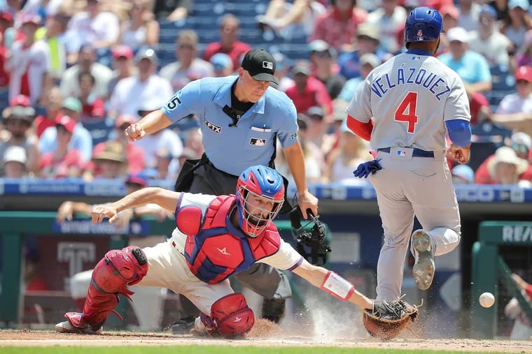 Phillies catcher Garrett Stubbs (left) reaches for the ball as Chicago Cubs right fielder Nelson Velázquez (right) scores in the third inning on Sunday.