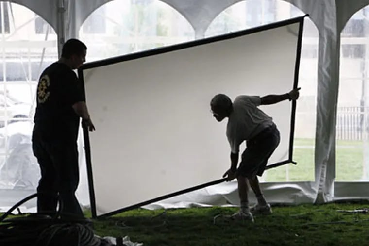 Jim Roach (left) and Keith Harewood move a video screen Friday in preperation for the Moore College of Art and Design Fashion Show on Saturday. (Elizabeth Robertson/ Staff Photographer)