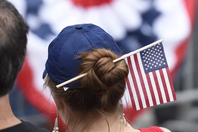 A woman has a flag stuck in her hair bun during Philadelphia's Celebration of Freedom ceremony at Independence Hall July 4, 2016.