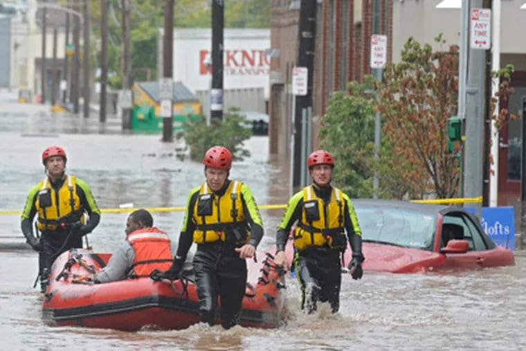 Fire Department members rescue a resident at the flooded Venice Lofts apartments on Friday. (Clem Murray / Staff Photographer)