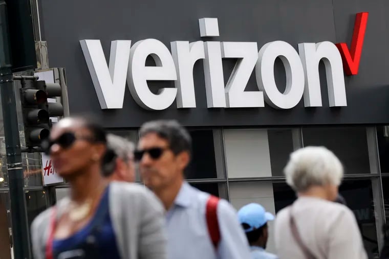 In this May 2, 2017, file photo, people walk past a Verizon store in Manhattan's midtown area, in New York. Verizon is getting rid of hidden fees and cable bundles that lock customers in long-term contracts.