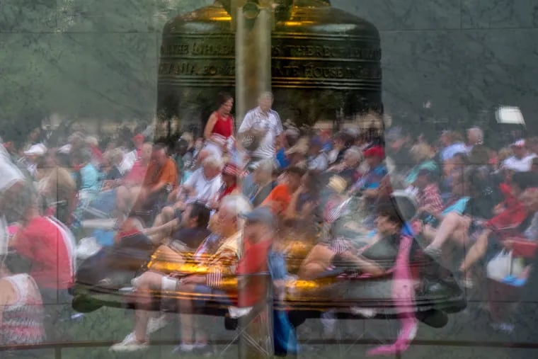 The audience is reflected in the glass of the Liberty Bell Pavilion (with the Bell inside) at the Philly Pops concert on the eve of the Fourth of July on Independence Mall July 3, 2019.