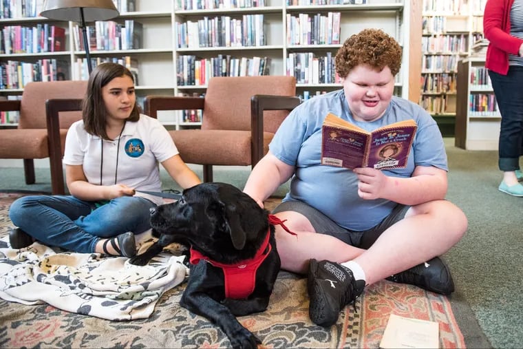 Seventh-grader Matthew Mattliocco regularly attends the Read to a Dog! program. His dad notes that the presence of the dog helps to ease Mattliocco's anxiety.