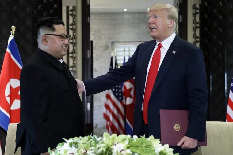 President Trump reaches for North Korea leader Kim Jong Un after they signed documents at the end of their summit on Tuesday.