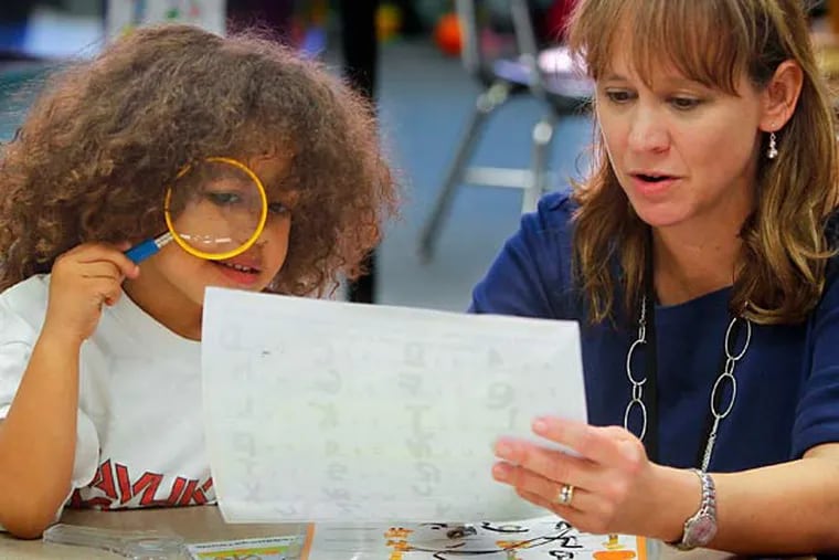 Kindergarden teacher Teresa Reaughworks with students like Madison McNeill on alphabet letters. She is a participant in a pilot program at the school, working with a new assessment for young kids that will become the standard for all preK-3 teachers starting next year. (Corey Lowenstein/Raleigh News & Observer/TNS)