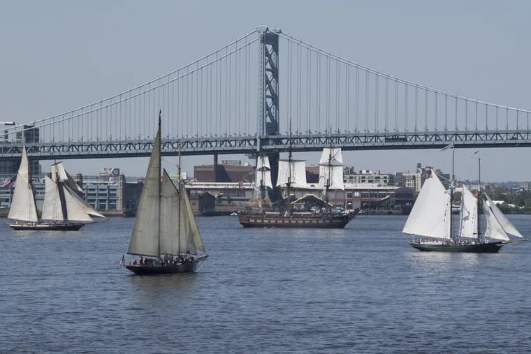 Tall ships sail through the waters of the Delaware River during the Parade of Sails at Penn’s Landing, Philadelphia.