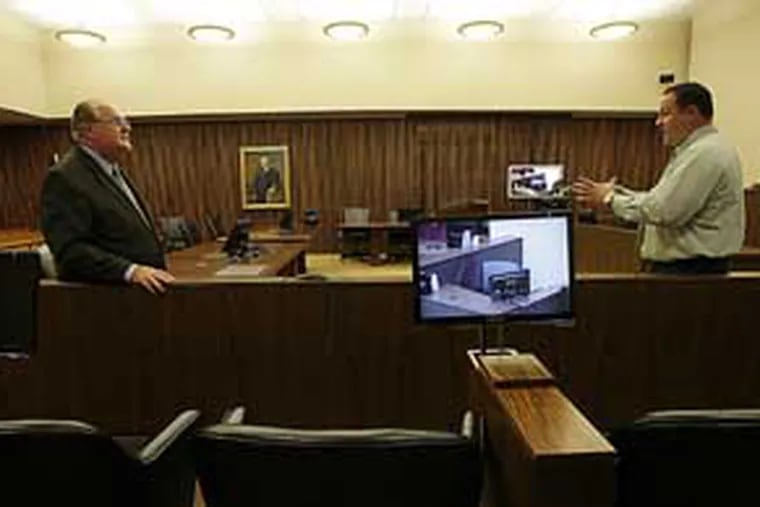Clerk of court, Michael Kunz (left) and court technology administrator Ed Morrissy, stand near a television monitor in the juror box in Judge John Padova's court room at the James A. Byrne Federal Courthouse on Tuesday, August 10, 2010.  (Yong Kim / Staff Photographer)