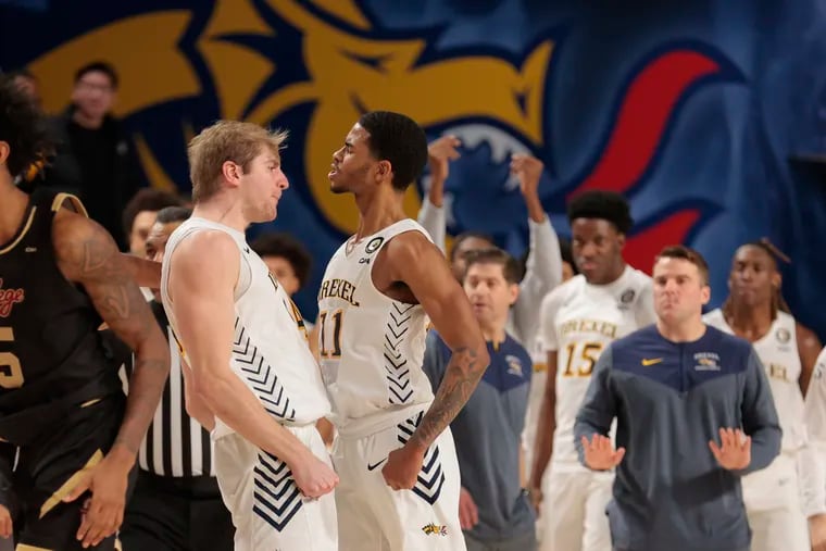 Justin Moore (right) of Drexel celebrates with Luke House after his shot with just over 3 second upset Charleston on Feb. 2, 2023.