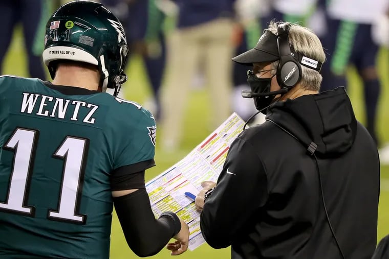 Eagles quarterback Carson Wentz and coach Doug Pederson take a look at the play chart against the Seahawks.