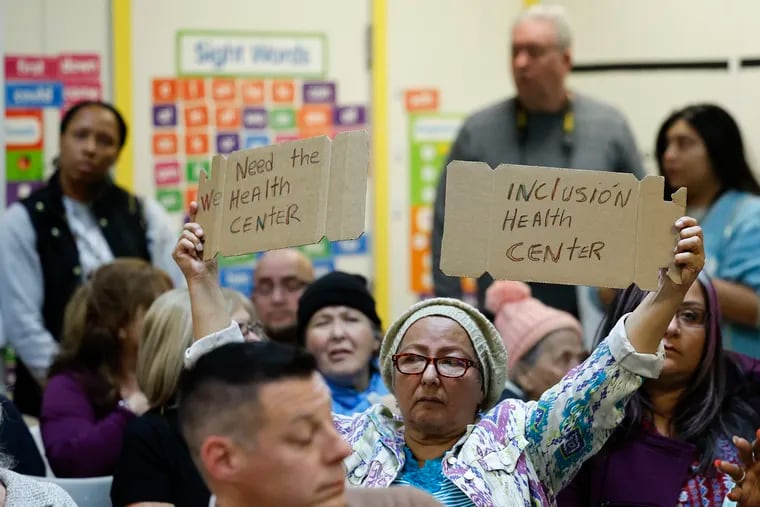 Maria Serna holds a sign in favor of the creation of a health center on the Friends Hospital campus along Roosevelt Boulevard in 2025 during a community meeting at the Simpson Recreation Center on Saturday.