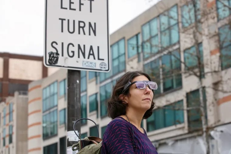 Dr. Megan Ryerson, a Professor in City and Regional Planning and Electrical Systems and Engineering at UPENN in the Area of Transportation, demonstrates a pair of specially equipped glasses, that record how people's eyes move when they travel in an urban environment, on the University of Pennsylvania campus, in Philadelphia, Tuesday, Dec. 5, 2017. JESSICA GRIFFIN / Staff Photographer