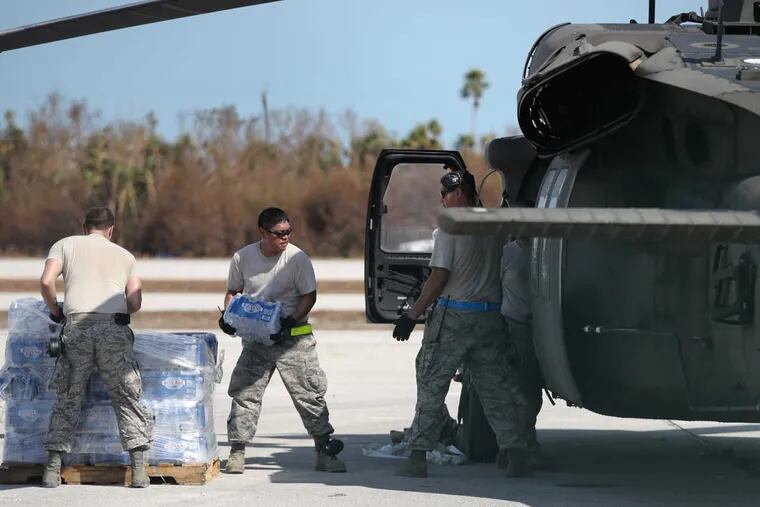 Soldiers and airmen from the Florida Army National Guard load bottled water into helicopters at a staging area at the Florida Keys Marathon International Airport.