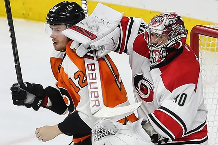 The Flyers' Michael Raffl tangles with the Hurricanes goalie Cam Ward during the second period at the Wells Fargo Center in Philadelphia, Thursday, April 9, 2015. (Steven M. Falk/Staff Photographer)