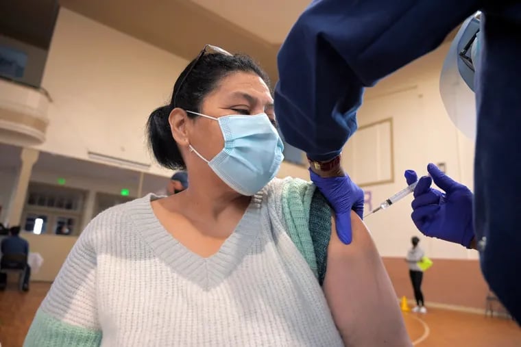 Lesbia Ruiz receives her vaccination from Theresa Williams, a registered nurse, during a coronavirus vaccination drive for the Hispanic population at Sacred Heart Church in Highlandtown, a vaccination site partnering with Johns Hopkins Hospital, on March 24, 2021.