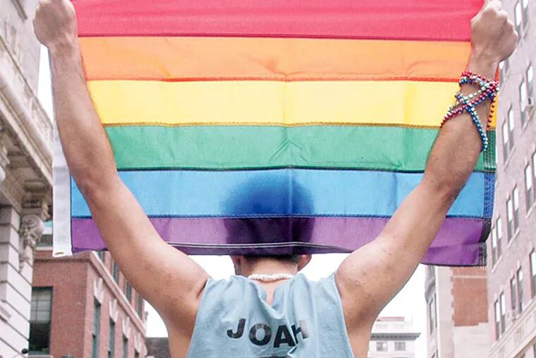 Jason Brendel holds a rainbow flag, representing diversity and LGBT equality. (Rebecca Barger)