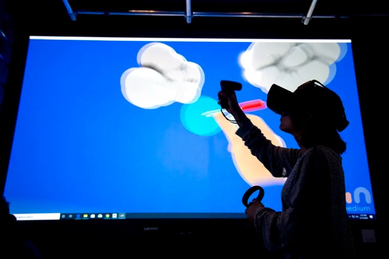 Game Art senior Azalea Rosado uses digital content creation (DCC) tools in virtual reality (projected on a large screen for classmates to see) in UArts' new VR class for arts students, gamers, and theater majors.