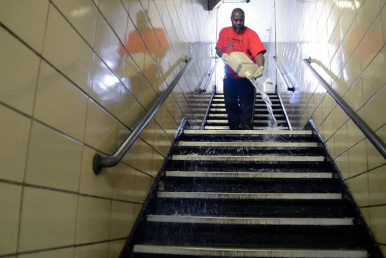 Renault Floyd pours bleach down the stairs at Locust and Juniper station in Philadelphia on Monday, June 16, 2014. Floyd has had the same job for 2 years, but after being laid-off along with ten others who clean the subway concourses. June 30th will be his last day. (VIVIANA PERNOT/Staff Photographer)