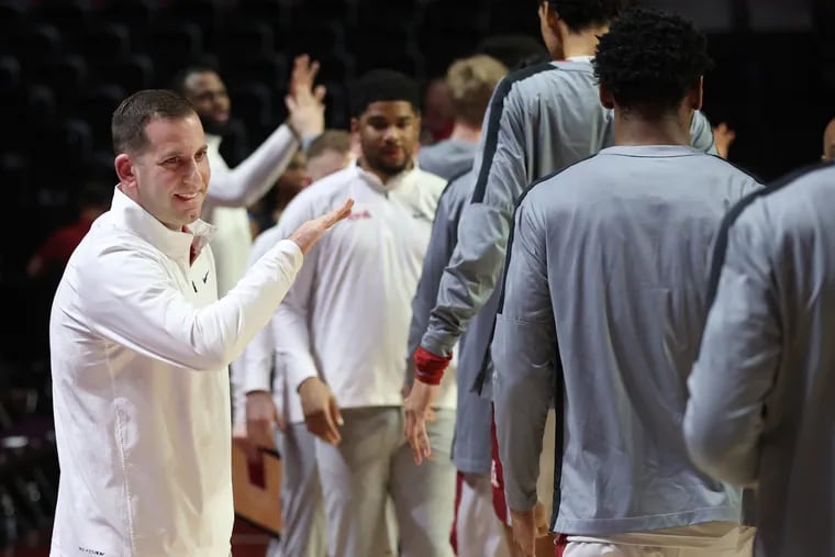 Coach Adam Fisher of Temple high-fiving the players before the team played East Carolina at the Liacouras Center on Jan. 10, 2024.