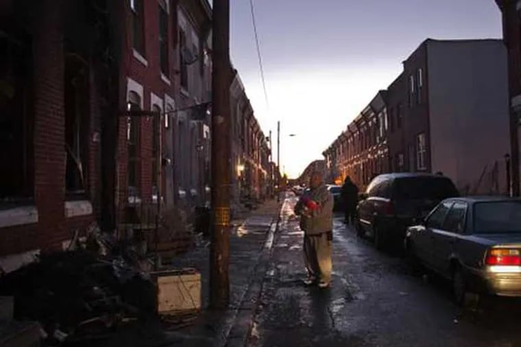 A family friend stands at the scene of a fire that killed two people on Daly Street in South Philadelphia on Thursday, Jan. 29, 2015. (Alejandro A. Alvarez / Staff)