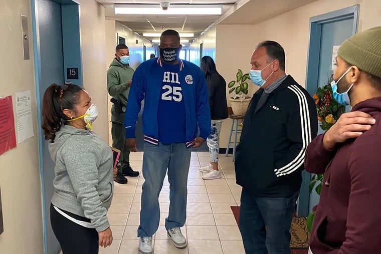 In a mayoral mask and Sixers gear, Atlantic City Mayor Marty Small Sr. campaigns in a high rise Sunday urging voters to reject an attempt to change the form of government. At right is City Council President George Tibbitt.