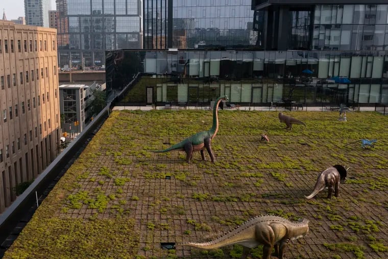 Dinosaurs roam the rooftop of one of the Riverwalk apartment buildings in Center City.