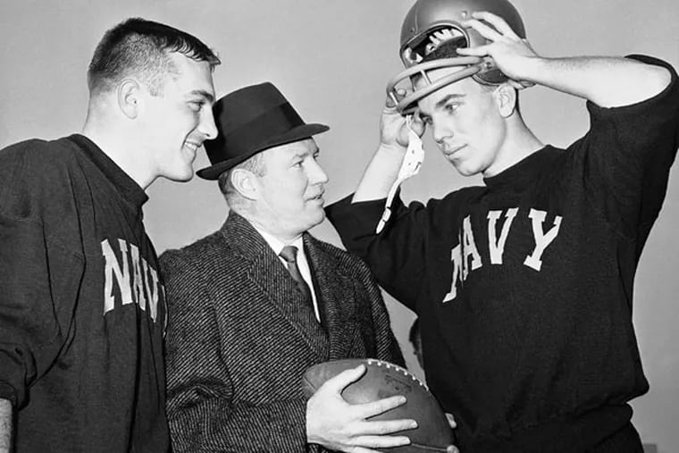 Navy coach Wayne Hardin, center, talks with his star quarterback,
Roger Staubach, right, in final workout in Philadelphia Stadium on Dec. 7, 1963, before annual battle against Army, with center Tom Lynch listening in at left. Navy is considered an 11-point favorite over Army and may win a Cotton Bowl bid if victorious. (Bill Achatz/AP)