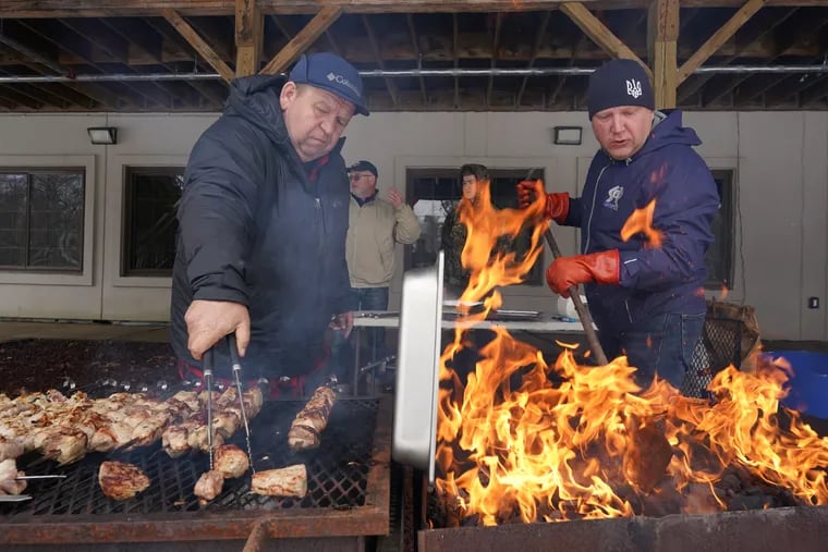 Taras Partyka (left) and Askold Sandursky cook pork kebabs for the food festival at St. Michael the Archangel Ukrainian Church in Jenkintown on Saturday, a fund-raiser for Ukrainian armed forces.