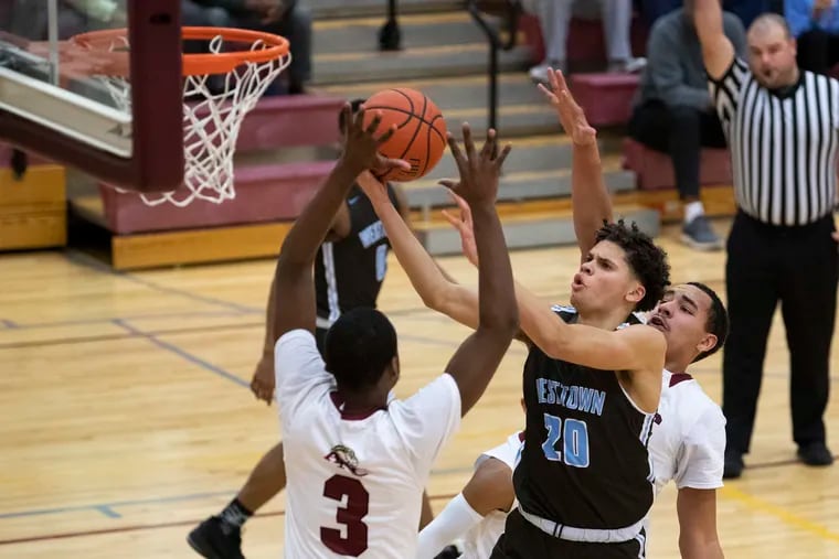 TJ Berger (center) of the Westtown School goes up for a shot against  between Anthony McCall (left) and Kai Allen of the Academy of the New Church on Thursday. Berger, a Penn recruit, scored 25 in an 81-57 win.