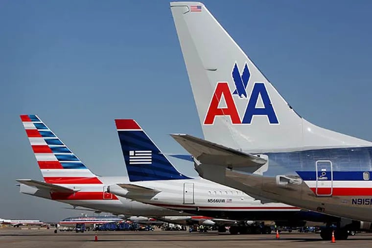 A US Airways Group Inc. airplane, center, sits flanked by AMR Corp.'s American Airlines' jets at a gate at Dallas Fort Worth Airport in Fort Worth, Texas, U.S., on Thursday, Feb. 14, 2013. (Mike Fuentes/Bloomberg)