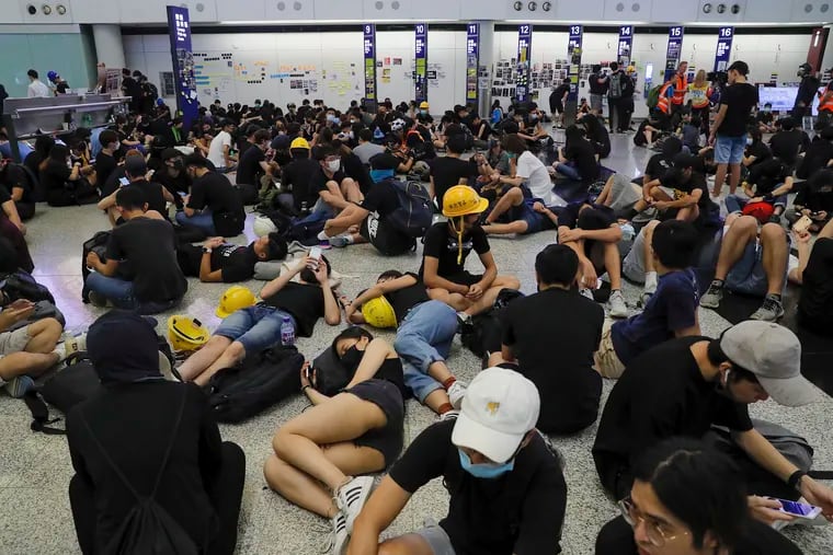 Protesters stage a sit-in protest at the Hong Kong International Airport, Monday, Aug. 12, 2019. One of the world's busiest airports canceled all flights after thousands of Hong Kong pro-democracy protesters crowded into the main terminal Monday afternoon. (AP Photo/Kin Cheung)