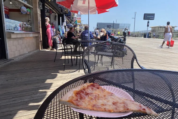 A view of mostly headless mannequins and a slice of pizza from the Food Court Pizza on the Boardwalk in Atlantic City, where a dozen pizza places all have their quirks. We ranked them.